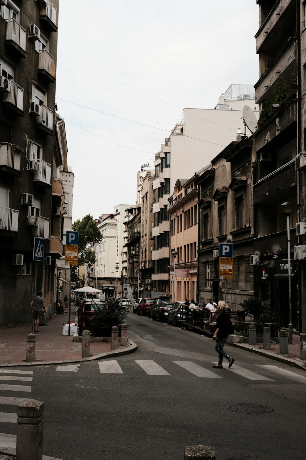 uma pessoa atravessando uma rua em uma cidade