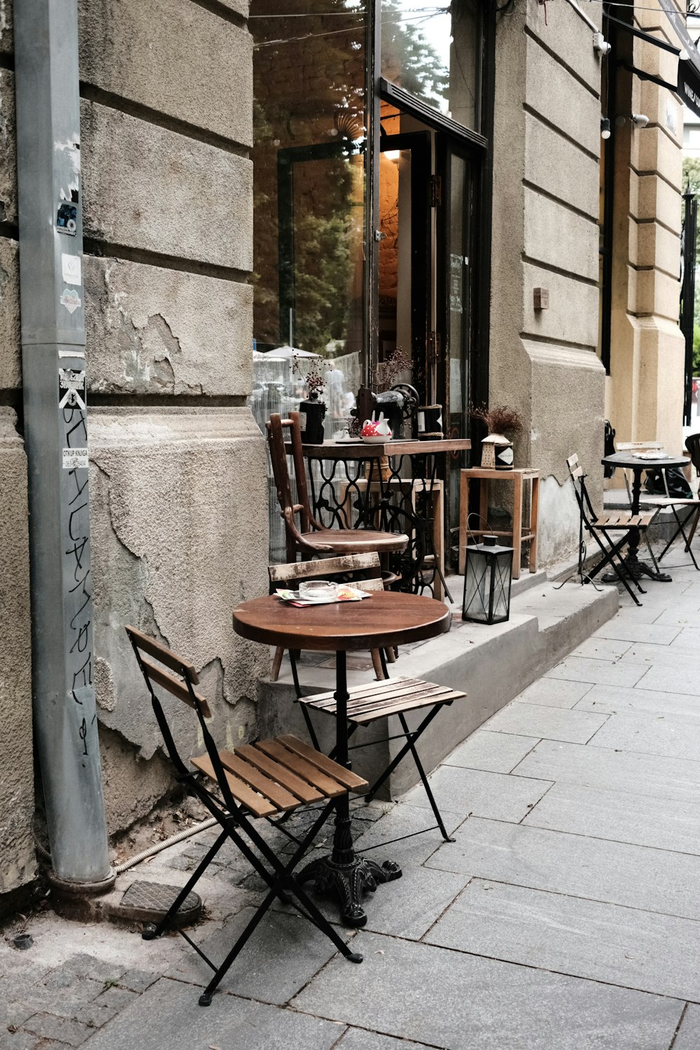 a couple of tables and chairs on a sidewalk