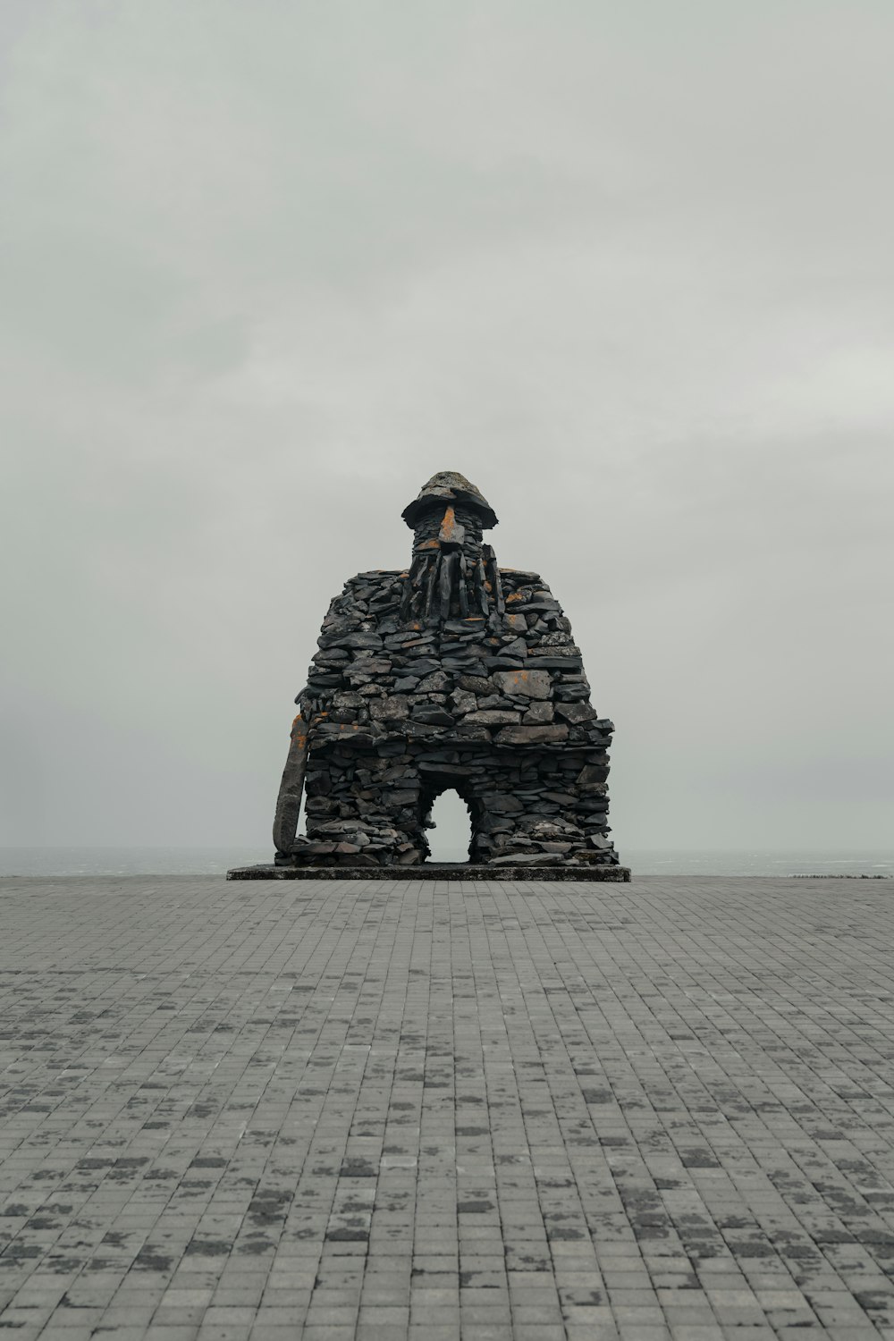 a statue of a woman sitting on top of a stone structure