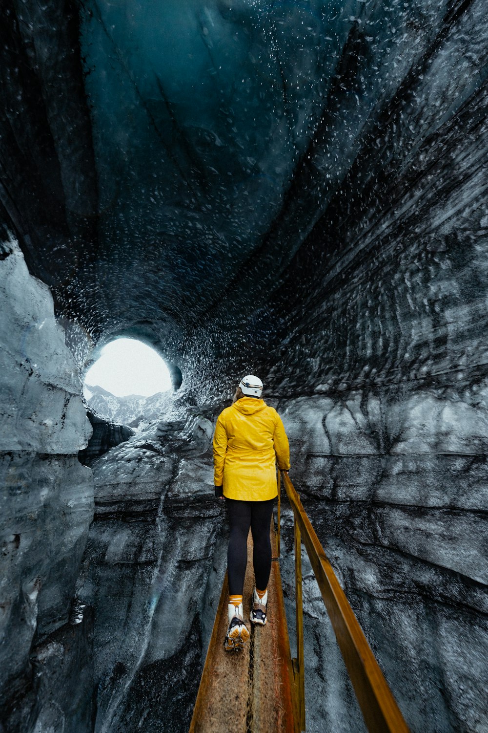 a person in a yellow jacket is walking through a tunnel
