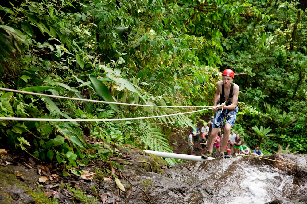 Un hombre caminando a través de una cuerda sobre un río