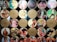 A collection of vintage film reels with covers featuring classic Indian movie posters. The reels are organized in a grid pattern, with colorful and artistic illustrations of actors and scenes from various films. Some reels have labels with titles or quotes.