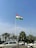 Young Indian man proudly holding the Tiranga flag in front of a sunny park.