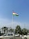 Young Indian man proudly holding the Tiranga flag in front of a sunny park.