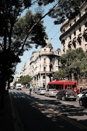 A bustling city street with electric buses and cyclists sharing the road.