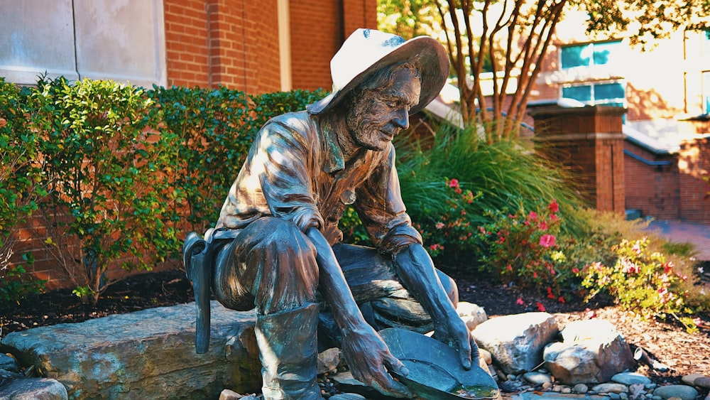 a statue of a man sitting on a rock