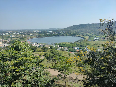 A sunlit view of Lago Chungara surrounded by vibrant community gardens and local houses.