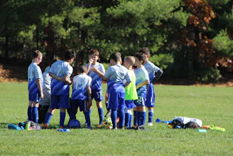 a group of young boys standing next to each other on a field