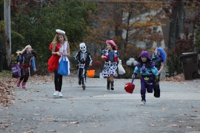Children dressed in Halloween costumes enjoying a themed party outdoors.