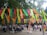 A vibrant outdoor festival scene with people enjoying art and music under colorful banners.