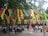 A vibrant outdoor festival scene with people enjoying art and music under colorful banners.