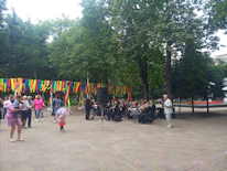 A lively community event with families enjoying music and food in a city park.