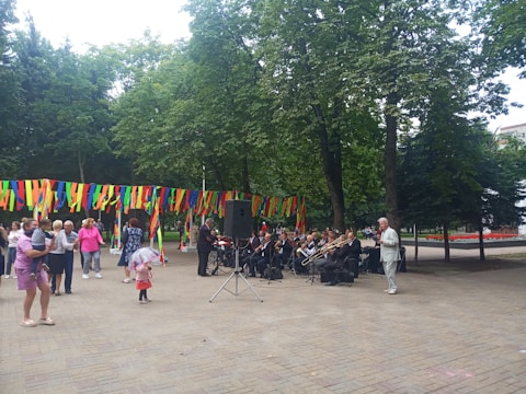 Children and adults enjoying a lively outdoor music event in the city park.