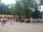 A group of friends gathered around a speaker, enjoying music together at a park.