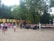A group of friends gathered around a speaker, enjoying music together at a park.