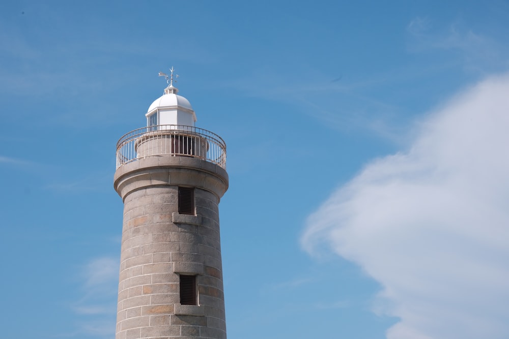 a tall light house sitting on top of a lush green field