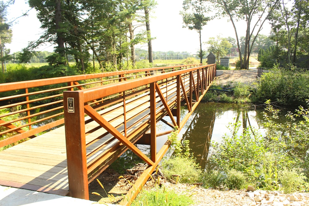 a wooden bridge over a small stream in a park