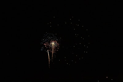 Close-up of a rocket firework launching into the starry night sky