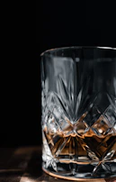 a glass of whiskey on a wooden table
