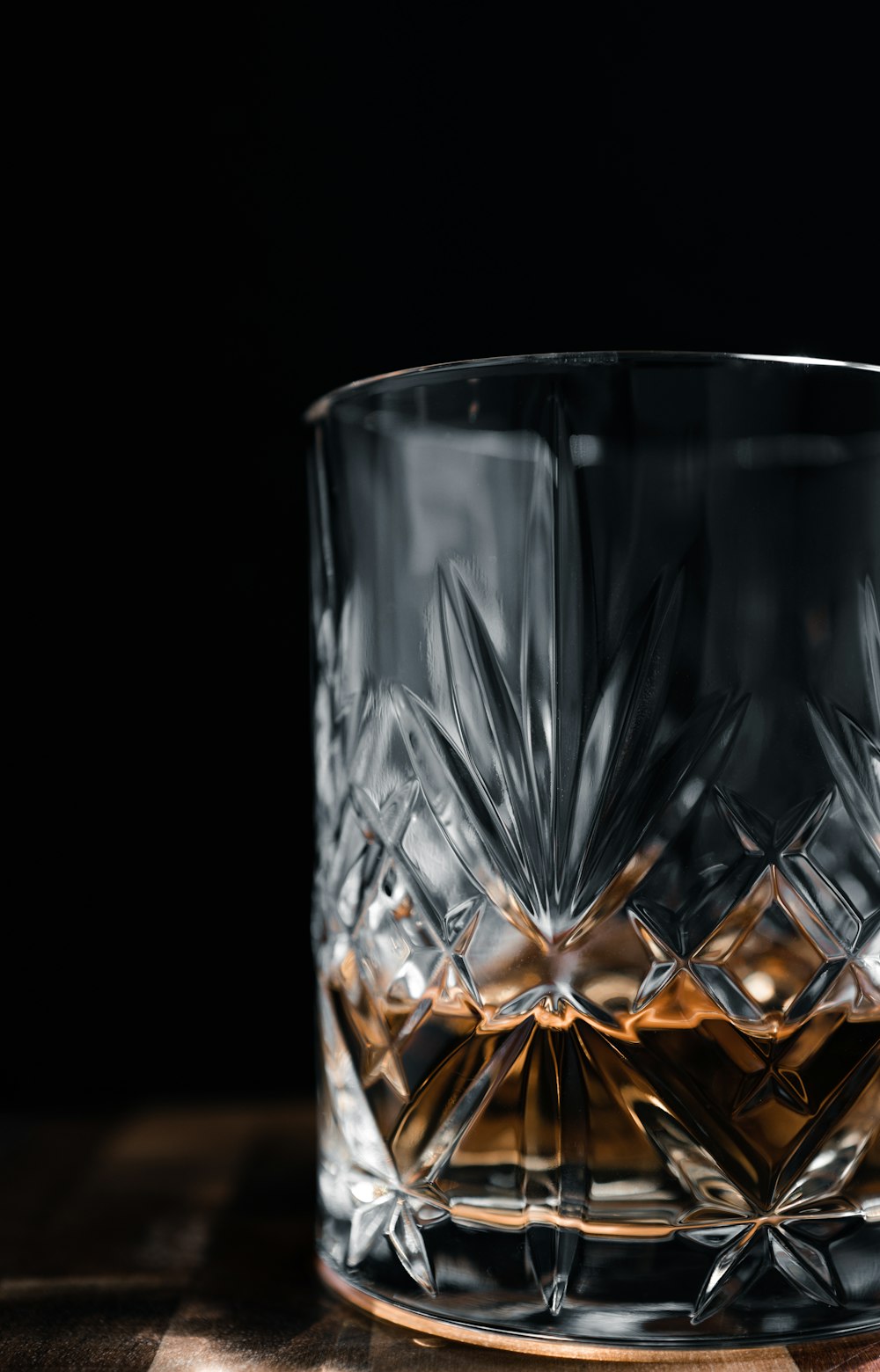 a glass of whiskey on a wooden table