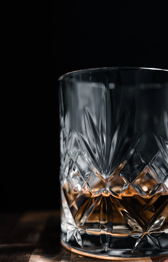 A glass of whisky on a wooden table