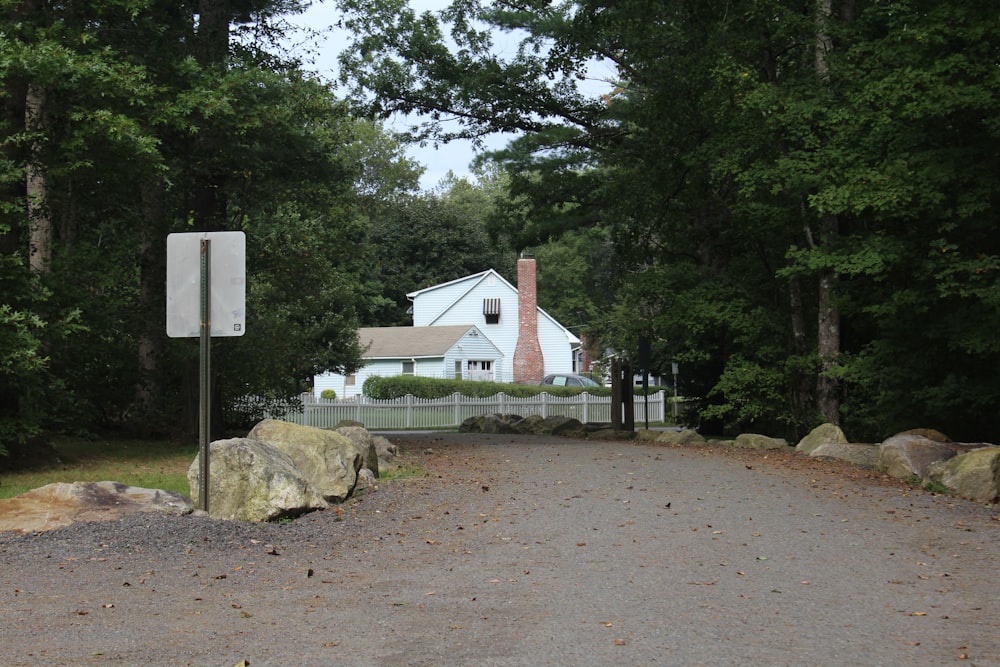 Une maison blanche entourée d’arbres et de rochers