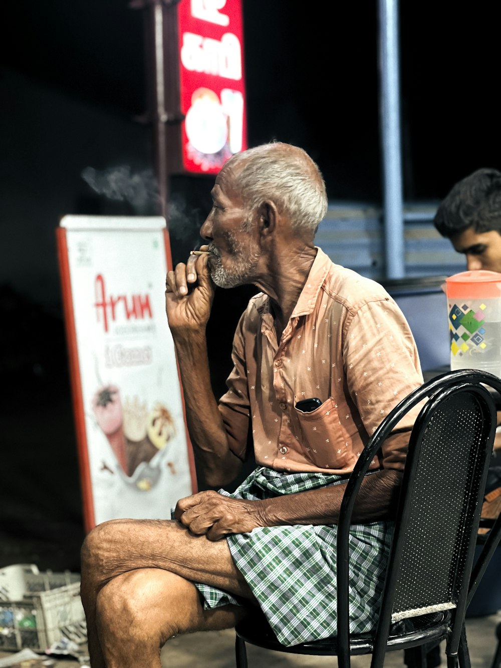 a man sitting on a chair smoking a cigarette