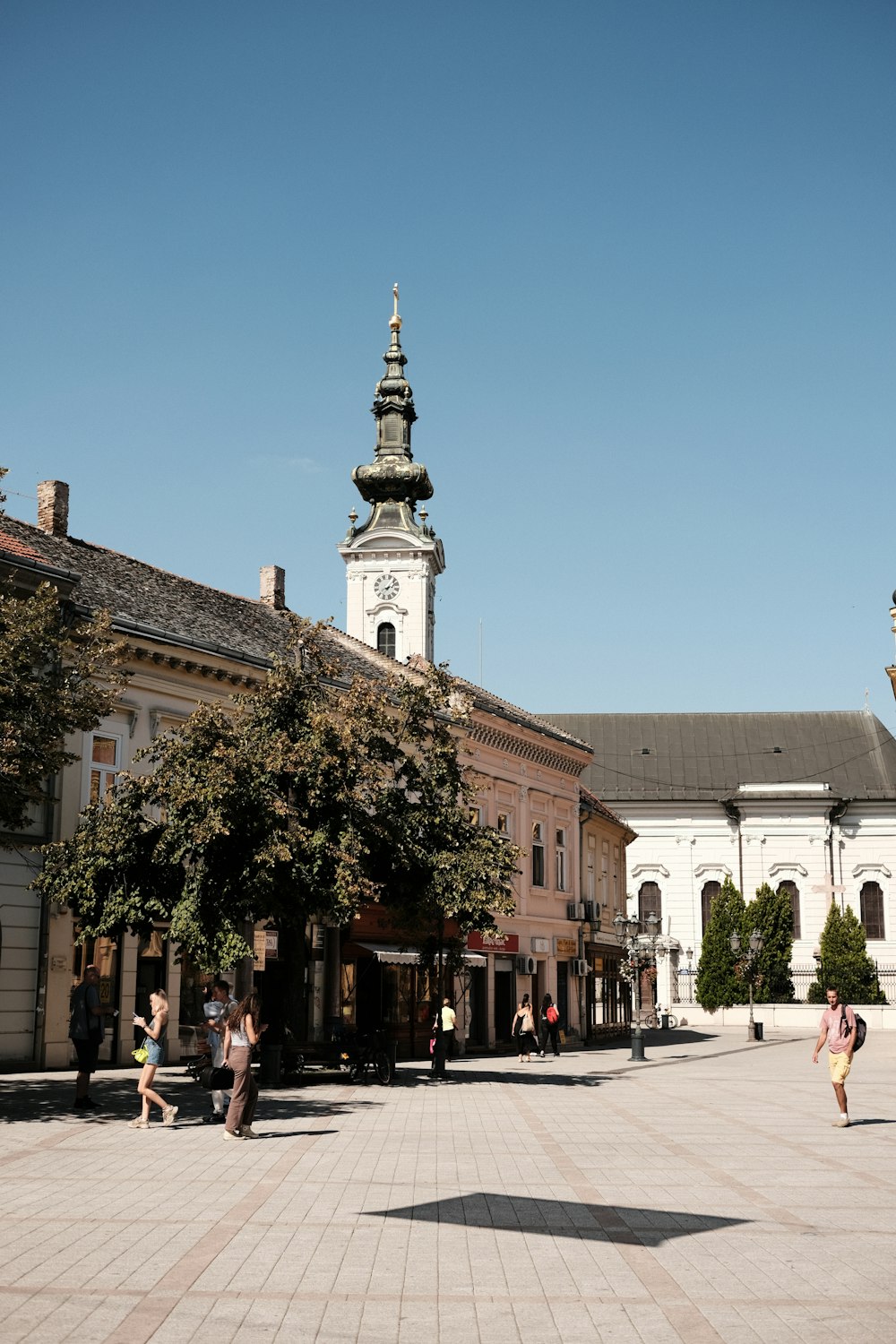 une tour de l’horloge au milieu d’une place de la ville