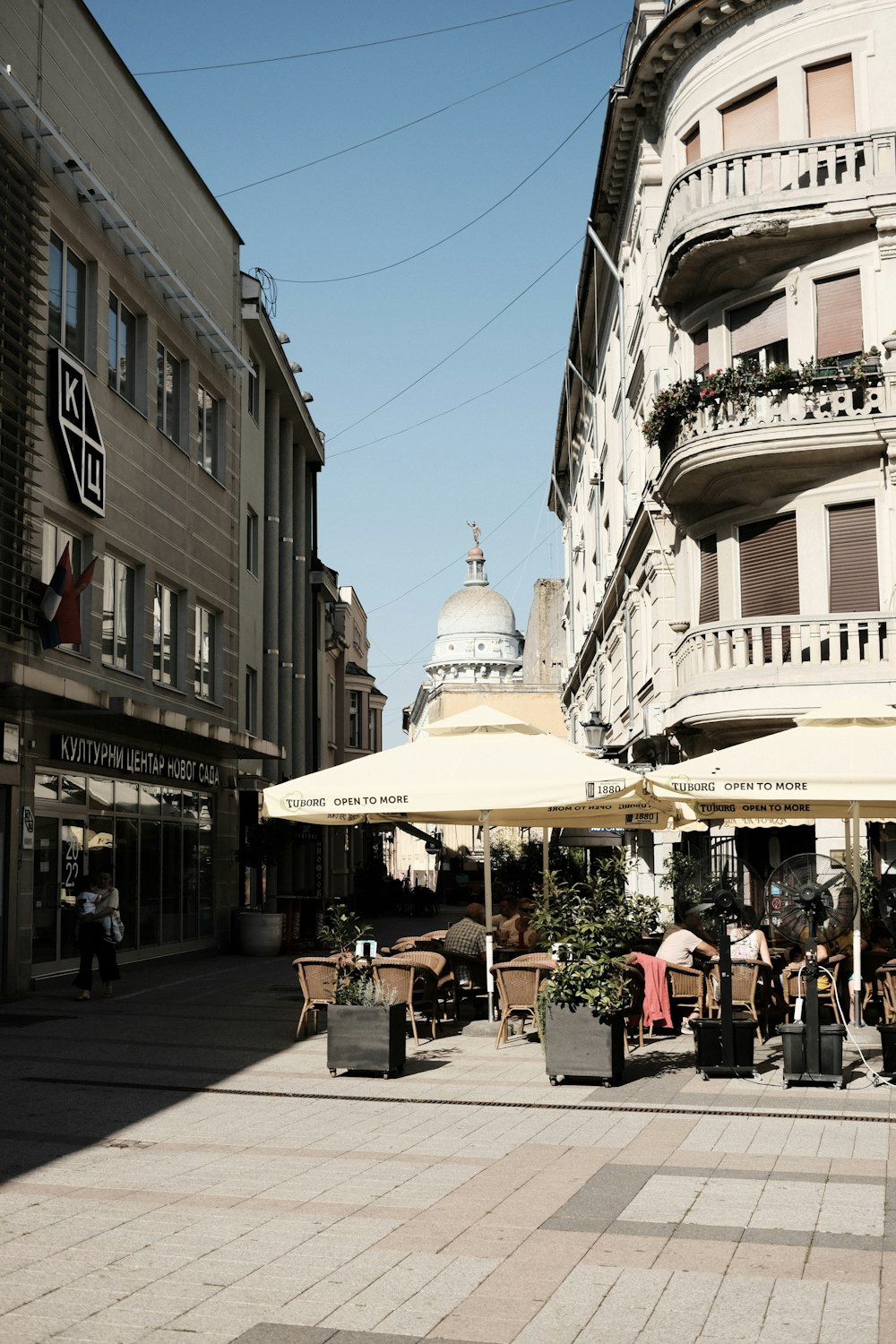 a group of people sitting at tables under umbrellas