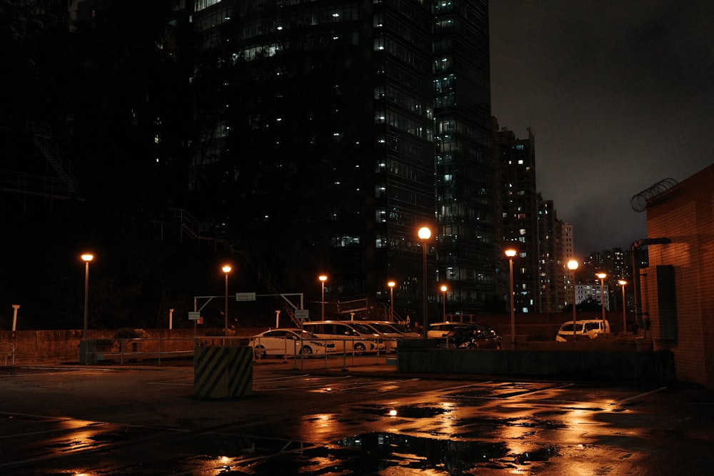 a wet parking lot at night with lights on