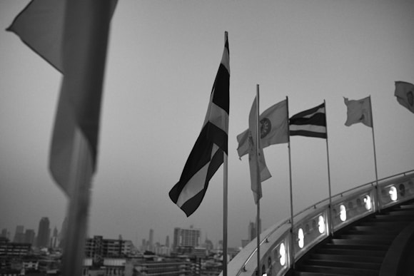 a black and white photo of flags flying in the wind