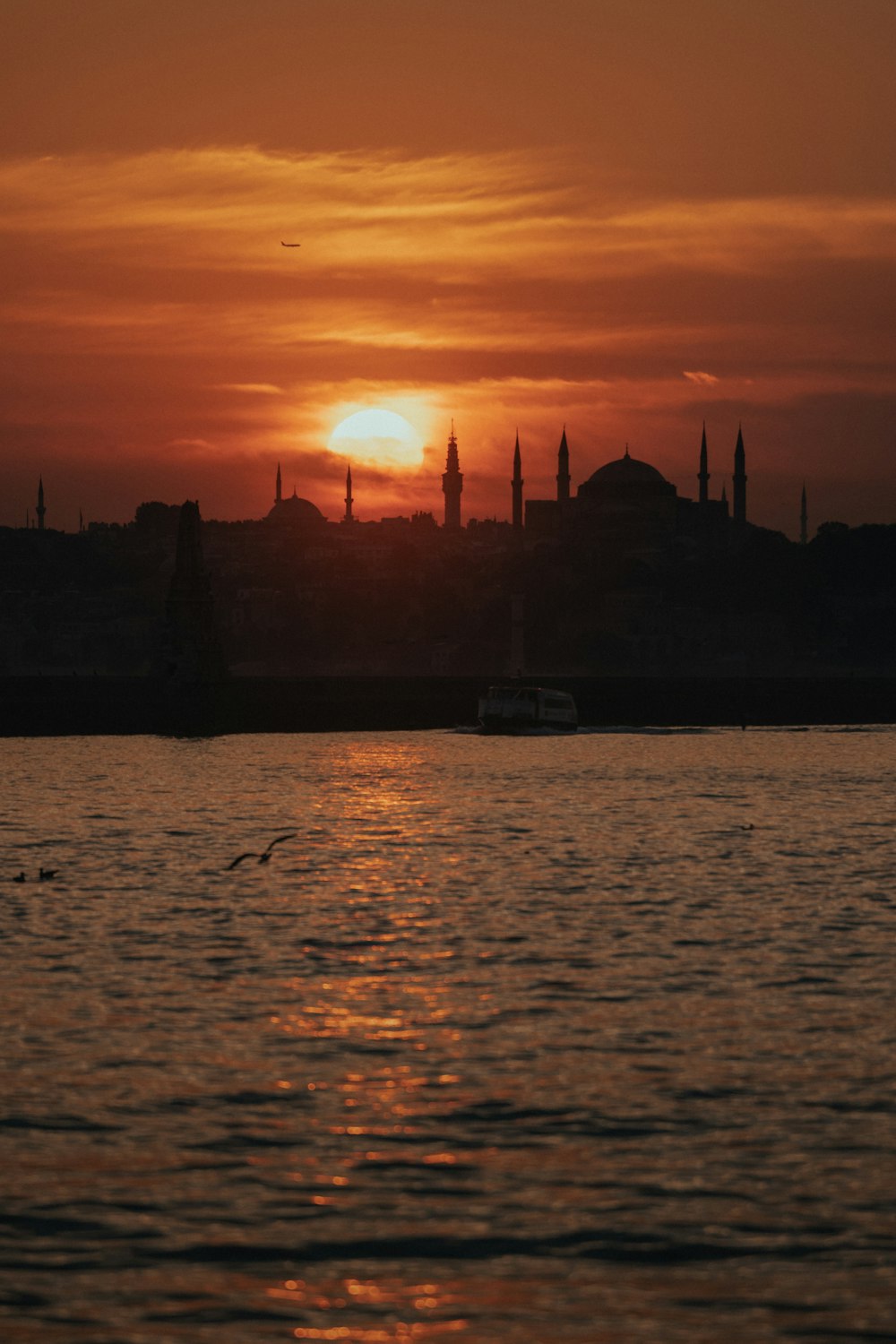 a large body of water with a sunset in the background