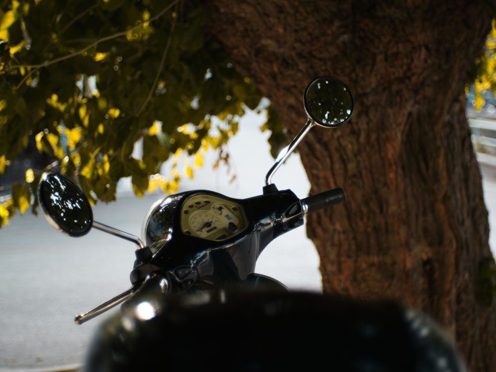 a motorcycle parked next to a tree on a street