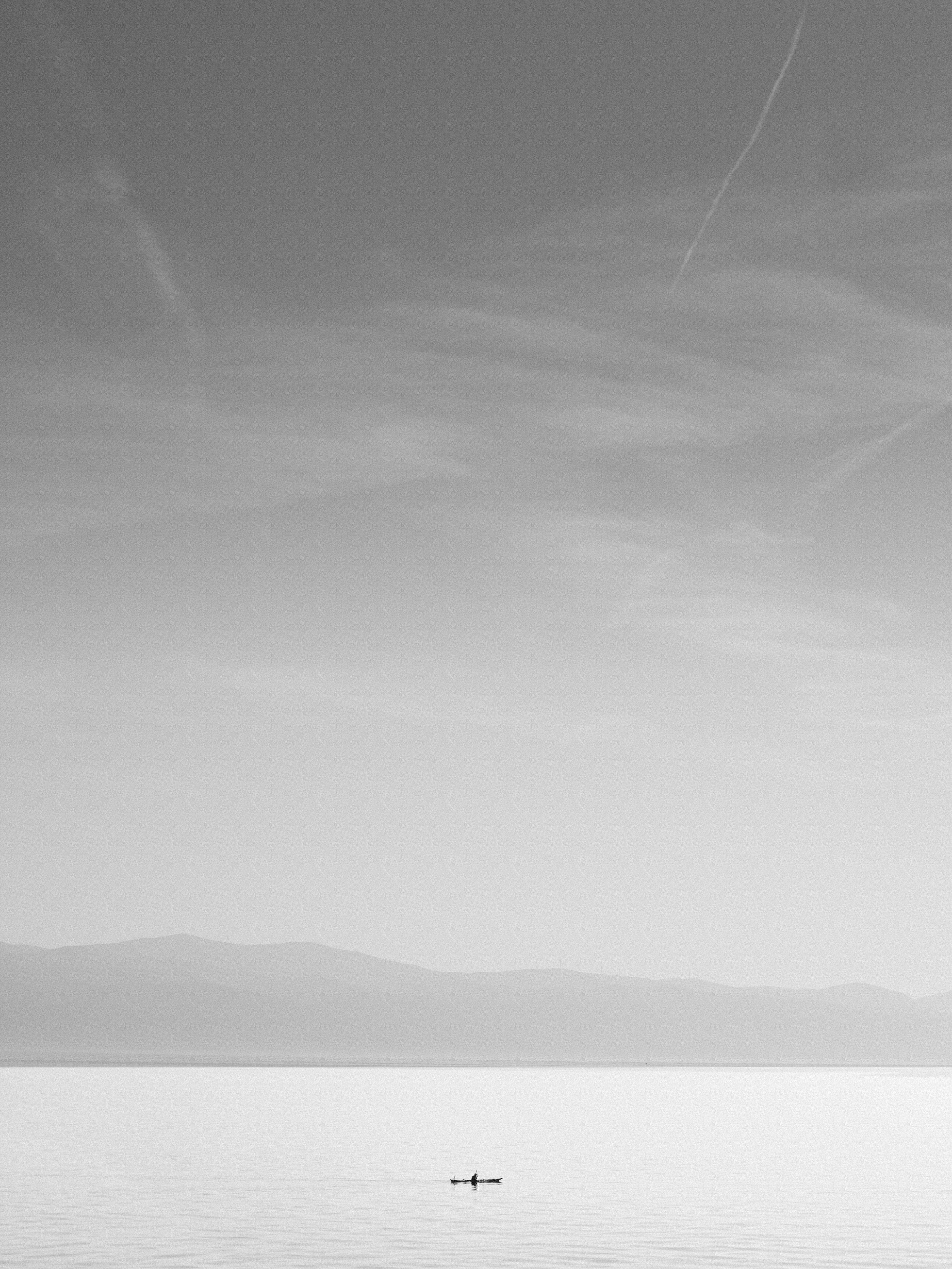 A lone boat floating in the middle of a large body of water photo ...