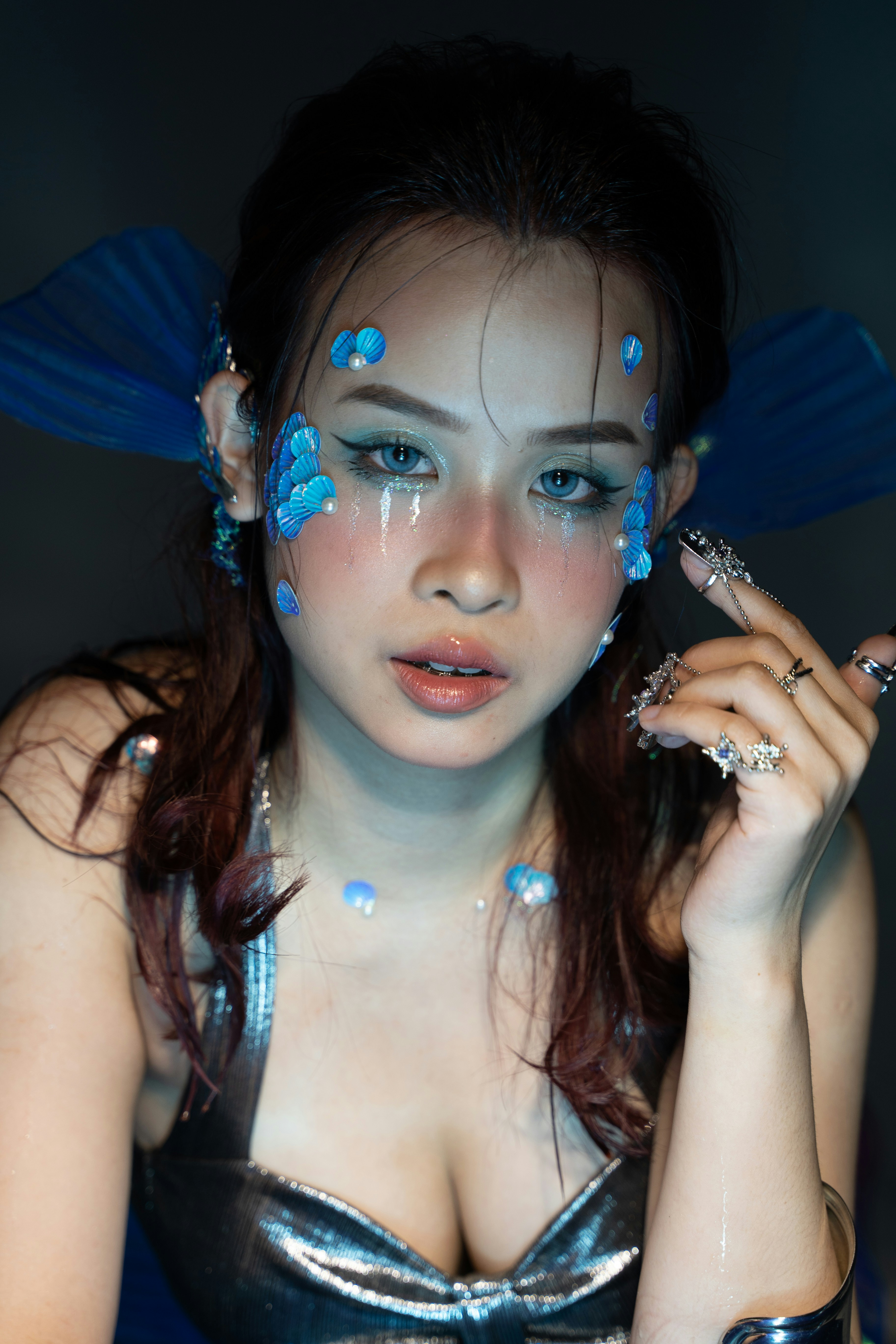 a woman with blue makeup and blue wings on her head