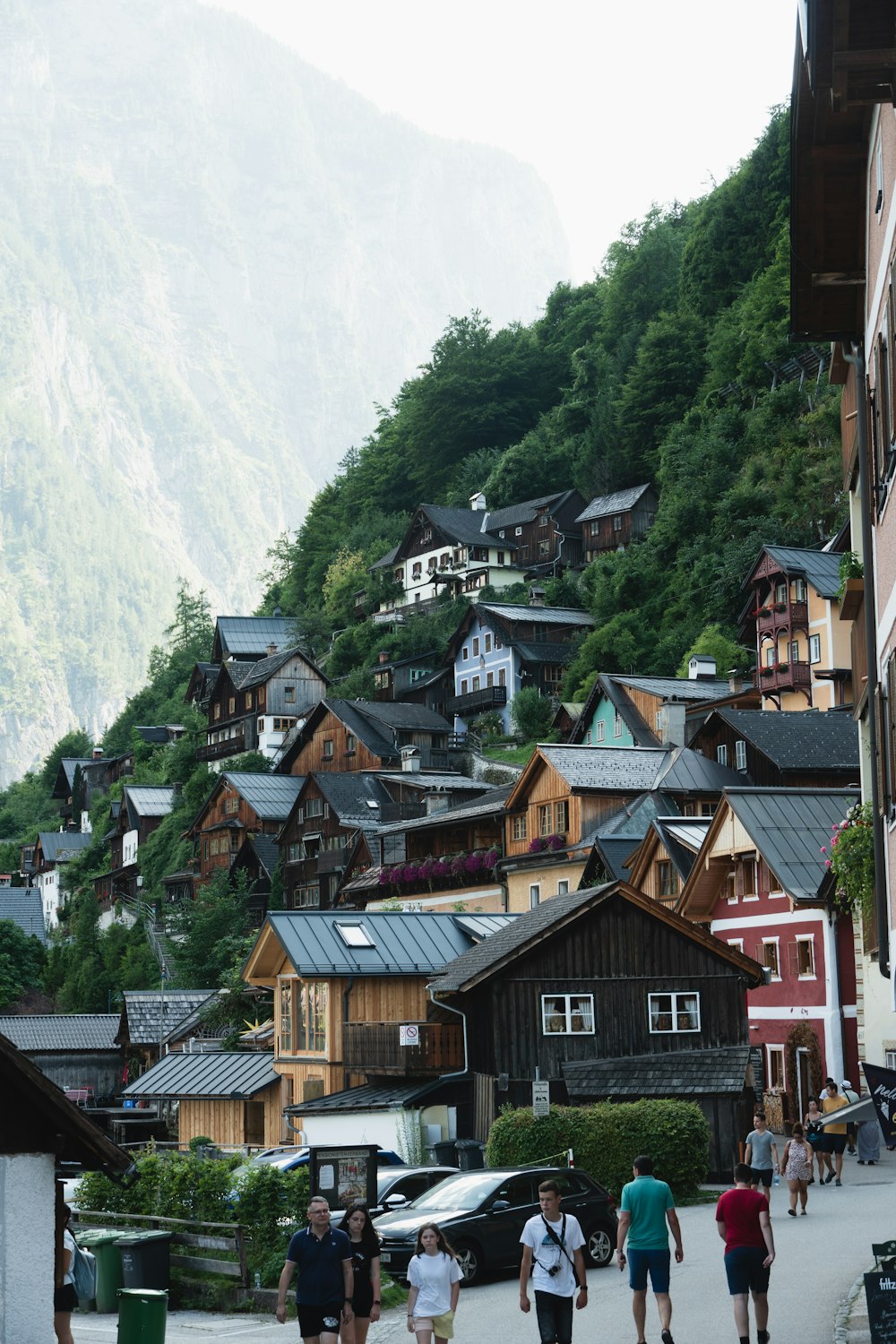 a group of people walking down a street next to a mountain