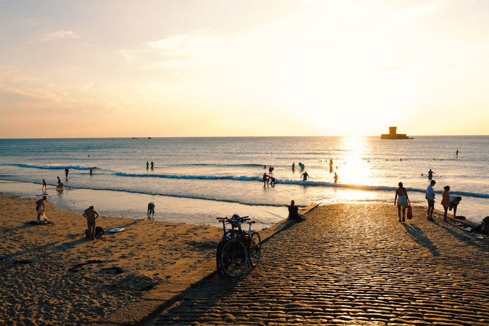 a group of people standing on top of a sandy beach