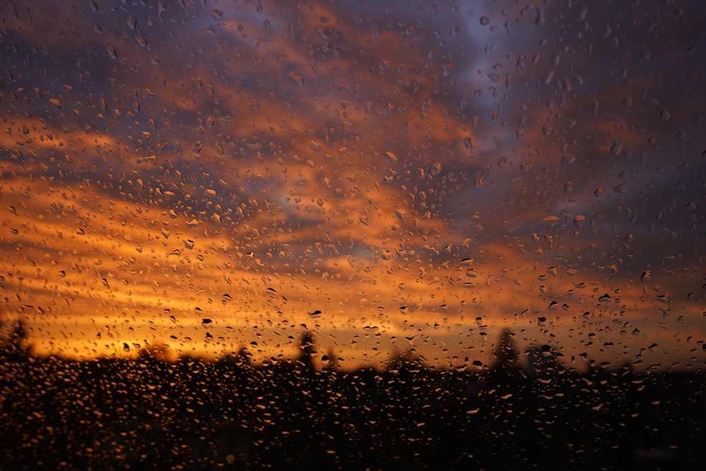 a sunset seen through a rain covered window