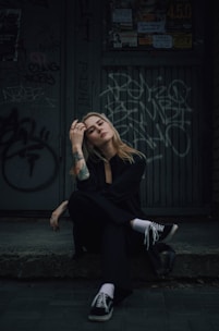 a woman sitting on the ground in front of a building Agencia La Movida Creación de contenido