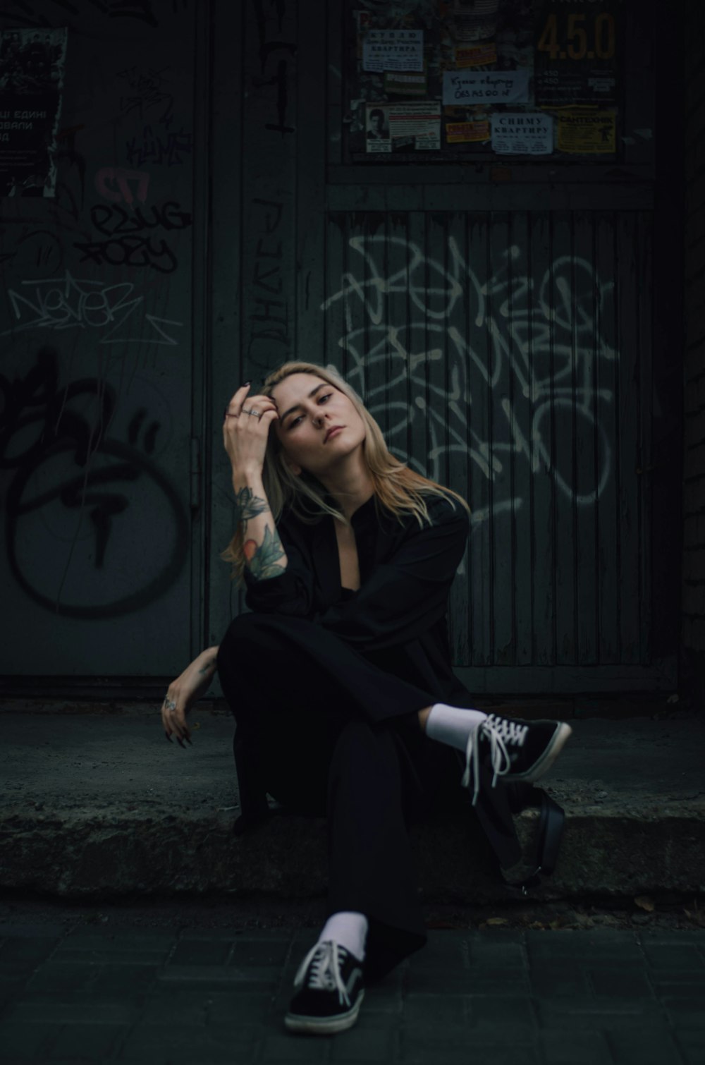 a woman sitting on the ground in front of a building