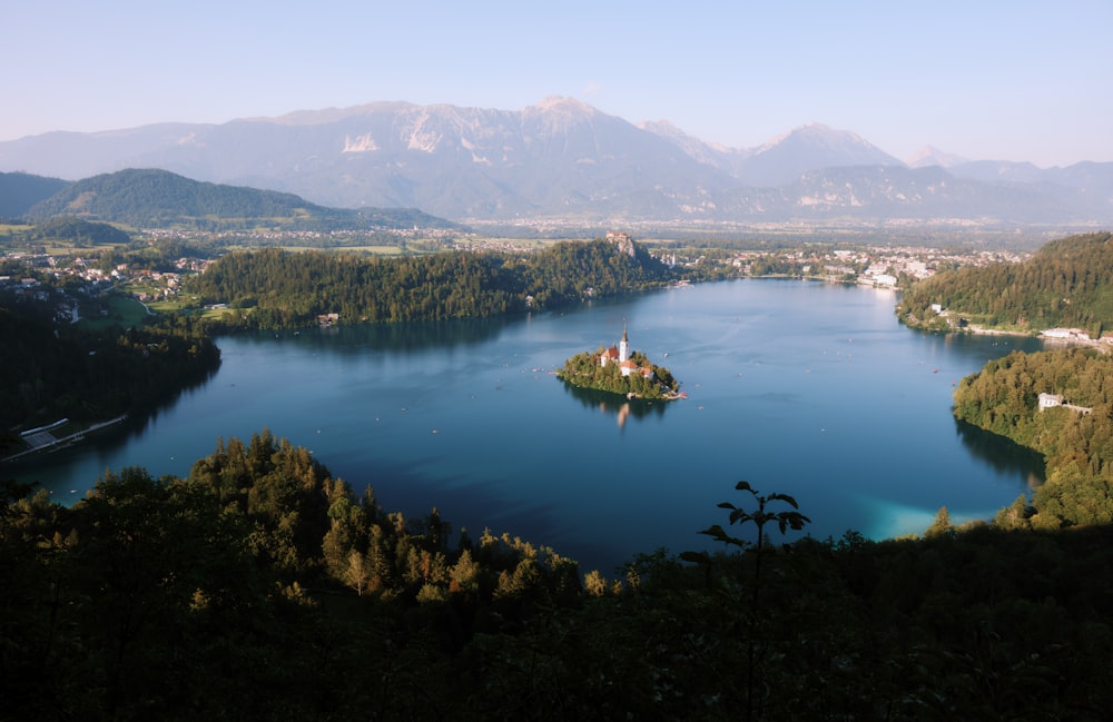 a lake surrounded by mountains with a small island in the middle