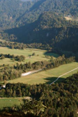 Aerial shot of a helicopter flying over lush green valleys on the pilgrimage route