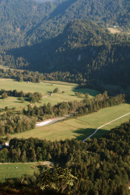 Aerial shot of a helicopter flying over lush green valleys on the pilgrimage route