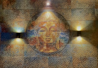 A textured wall art features a serene Buddha face in warm tones, illuminated by three soft lights. The artwork consists of a circular motif with detailed textures creating a mosaic effect.