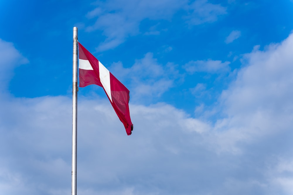 a red and white flag flying in the wind