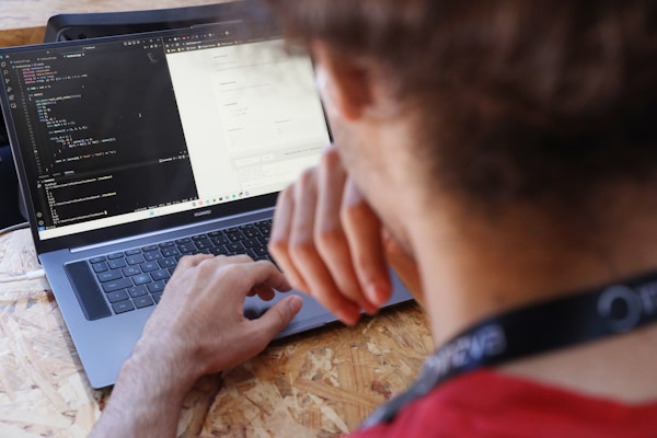 a man sitting at a table using a laptop computer