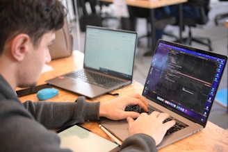 a man sitting in front of a laptop computer