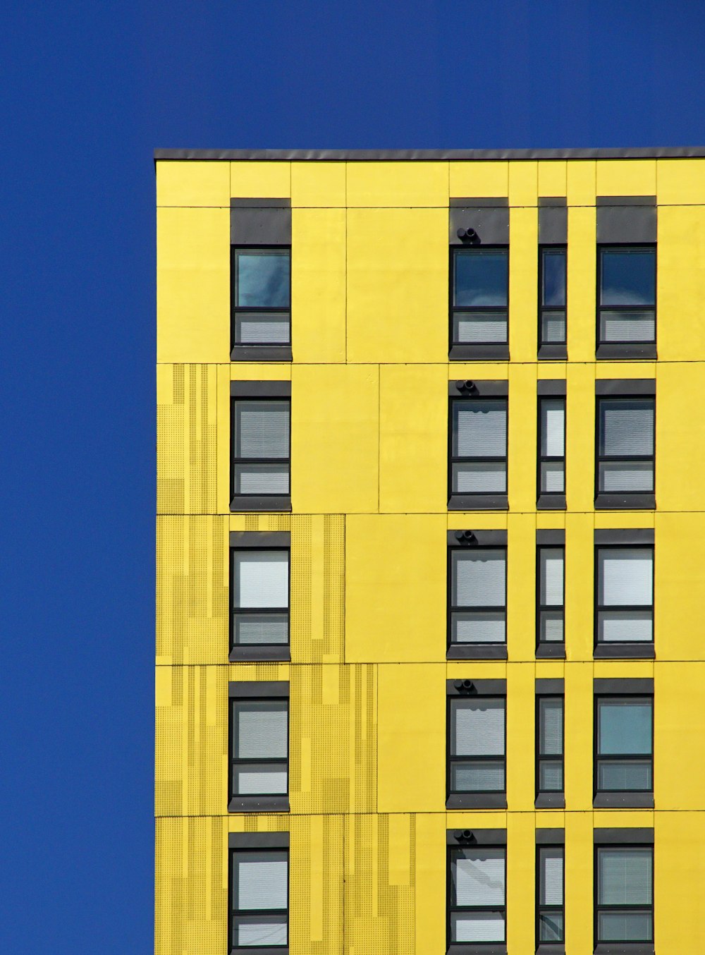 a tall yellow building with lots of windows