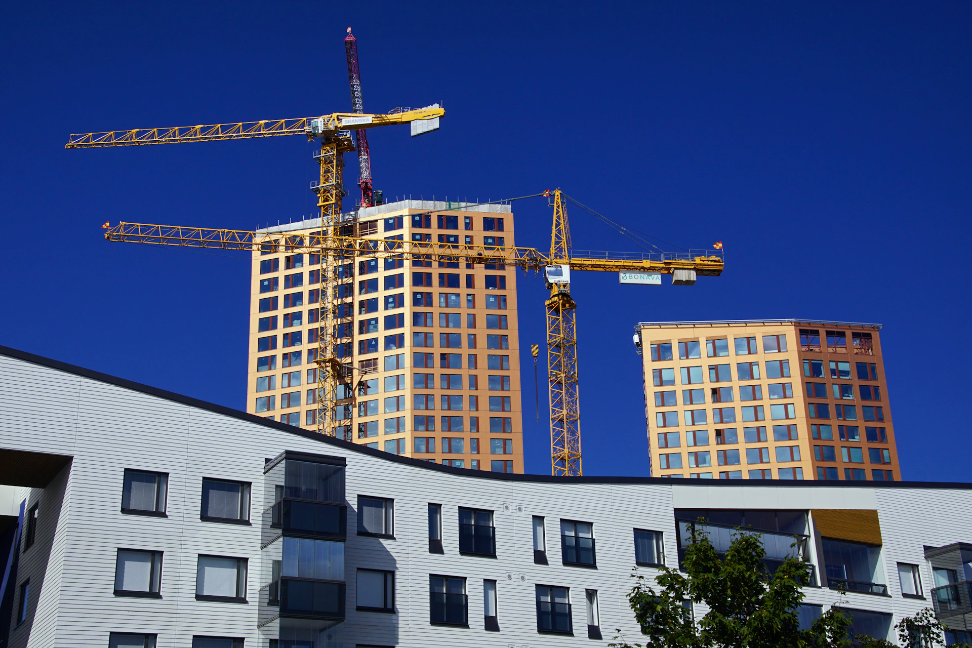 a building under construction with cranes in the background