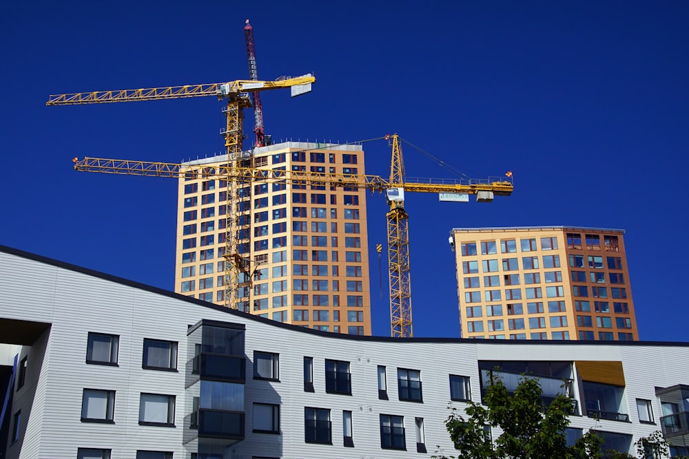 a building under construction with cranes in the background
